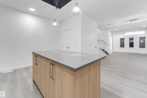The property features an open-concept living area with light wood-style flooring and white walls - 444 Crystal Creek Link, Leduc, AB - Indoor