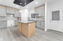 The kitchen features light grey cabinetry, a central island with a light-colored countertop, and recessed lighting - 444 Crystal Creek Link, Leduc, AB  - Indoor Photo Showing Kitchen 
