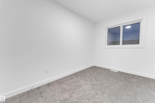 This space features neutral white walls, a window with white trim, and a grey carpet - 444 Crystal Creek Link, Leduc, AB - Indoor Photo Showing Other Room