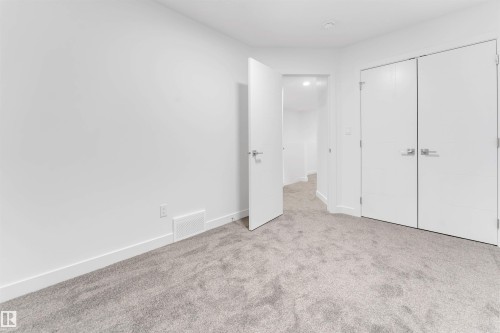 This room features light grey carpet flooring, white baseboards, and white walls - 444 Crystal Creek Link, Leduc, AB - Indoor Photo Showing Other Room