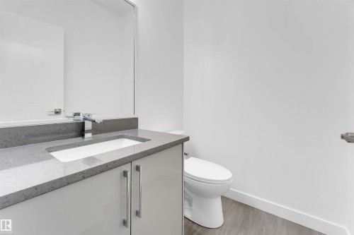 The bathroom features a vanity with a light gray countertop and a white integrated sink, complemented by a contemporary chrome faucet - 444 Crystal Creek Link, Leduc, AB - Indoor Photo Showing Bathroom