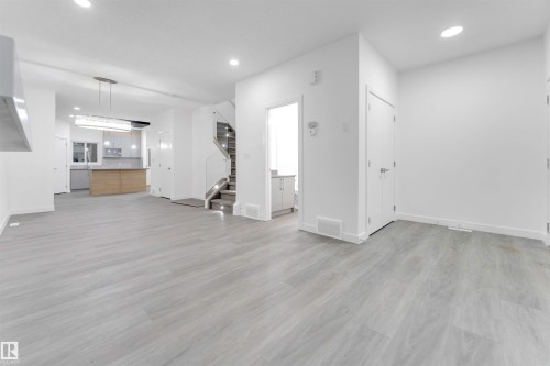 This bright, open concept main living area features light-toned flooring, white walls, and recessed lighting - 444 Crystal Creek Link, Leduc, AB - Indoor Photo Showing Other Room