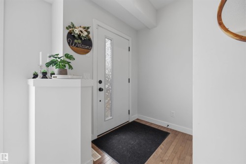 Entryway featuring a white door with a textured glass insert, hardwood flooring, and light-colored walls - 7123 Cardinal Way, Edmonton, AB - Indoor Photo Showing Other Room