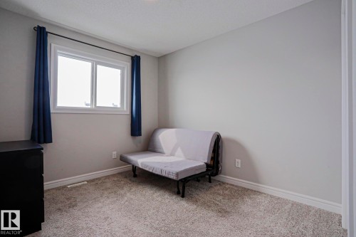 The room features light gray walls, a window with a white frame, and light-colored carpeting - 1424 Mcconachie Boulevard, Edmonton, AB - Indoor