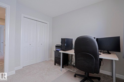 The room features light gray walls, light gray carpet, and white bi-fold closet doors - 1424 Mcconachie Boulevard, Edmonton, AB - Indoor Photo Showing Office