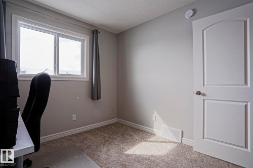 This room features light gray walls, a window with white trim, and light-colored carpeting - 1424 Mcconachie Boulevard, Edmonton, AB - Indoor Photo Showing Office