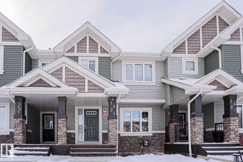 The property features a multi-level facade with horizontal siding, stone accents, and contrasting trim - 1424 Mcconachie Boulevard, Edmonton, AB - Outdoor With Facade