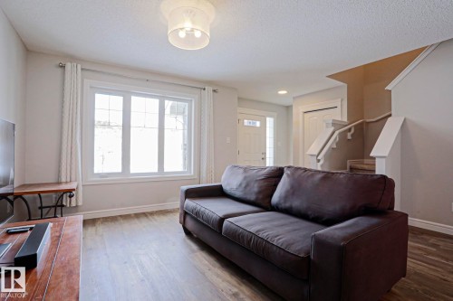 Living area featuring a large window providing natural light, durable flooring, and a ceiling light fixture - 1424 Mcconachie Boulevard, Edmonton, AB - Indoor Photo Showing Living Room