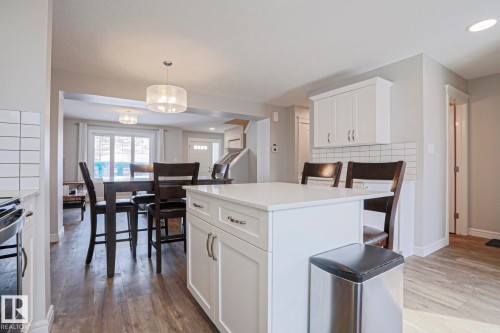 Open concept living area featuring a kitchen island with white cabinetry and a light-colored countertop - 1424 Mcconachie Boulevard, Edmonton, AB - Indoor