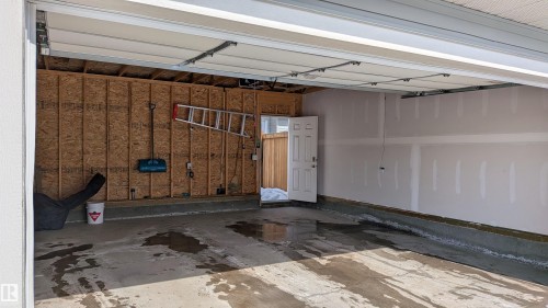 The property features a garage with a concrete floor and an overhead door - 1424 Mcconachie Boulevard, Edmonton, AB - Indoor Photo Showing Garage