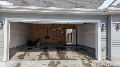 The property includes a spacious two-car garage with a gray shingle roof and light gray siding - 1424 Mcconachie Boulevard, Edmonton, AB - Outdoor With Exterior