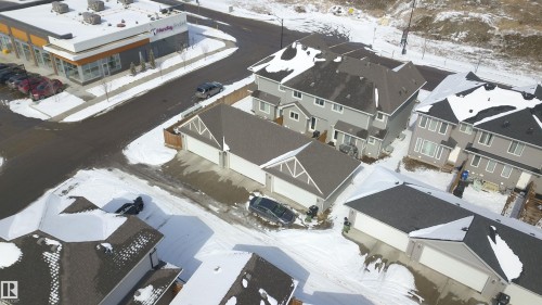 Aerial view showcasing the residential area with detached properties and townhomes, featuring a commercial building nearby - 1424 Mcconachie Boulevard, Edmonton, AB - 
