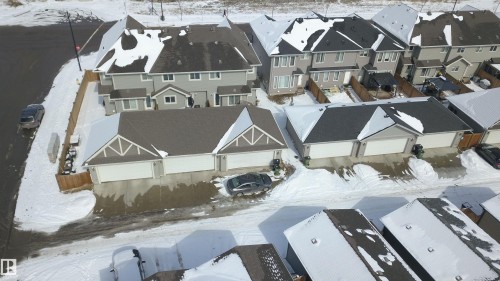 Aerial view of the property and surrounding neighborhood, featuring homes with snow-covered roofs and paved driveways - 1424 Mcconachie Boulevard, Edmonton, AB - 