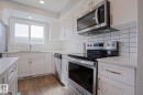 The kitchen features white cabinetry, a stainless steel microwave and stove, a white tiled backsplash, and light-colored countertops - 1424 Mcconachie Boulevard, Edmonton, AB  - Indoor Photo Showing Kitchen With Upgraded Kitchen 