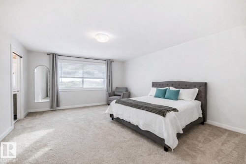 Spacious room featuring light-colored carpeting, white walls, a large window with blinds and drapes, and an overhead light fixture - 2935 Chokecherry Common, Edmonton, AB - Indoor Photo Showing Bedroom