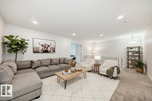 This versatile living area features light-colored walls, recessed lighting, and a neutral-toned carpeted floor - 2935 Chokecherry Common, Edmonton, AB - Indoor Photo Showing Living Room