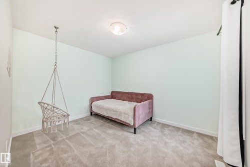 This room features light-colored walls and grey carpet, creating a neutral backdrop - 2935 Chokecherry Common, Edmonton, AB - Indoor Photo Showing Other Room