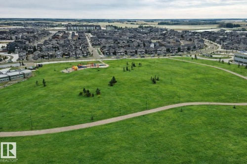 Expansive green space with walking paths, mature trees, and a dedicated play area, all within close proximity to residential developments - 2935 Chokecherry Common, Edmonton, AB - Outdoor With View
