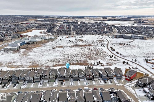 Aerial view of the property and its surrounding neighbourhood, featuring nearby properties, a paved path, and a body of water - 2935 Chokecherry Common, Edmonton, AB - Outdoor With View