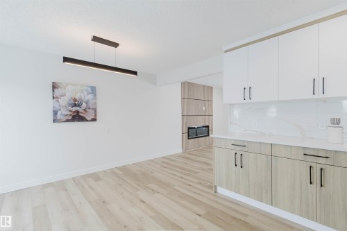The property features modern light wood flooring, white walls, and a contemporary linear light fixture - 11528 42 Avenue, Edmonton, AB - Indoor