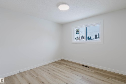 This room features light-toned flooring, white walls, and a window with white trim - 11528 42 Avenue, Edmonton, AB - Indoor Photo Showing Other Room