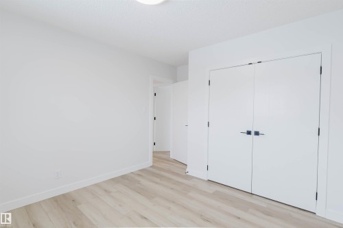 This room features light-toned wood-style flooring, white walls, and a white ceiling - 11528 42 Avenue, Edmonton, AB - Indoor Photo Showing Other Room