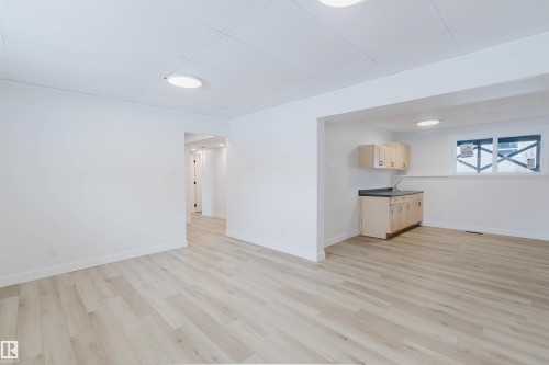 This expansive room features light-toned flooring, white walls, and recessed lighting fixtures - 11528 42 Avenue, Edmonton, AB - Indoor