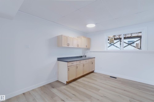 This room features light wood-look flooring, white walls, and a window providing natural light - 11528 42 Avenue, Edmonton, AB - Indoor