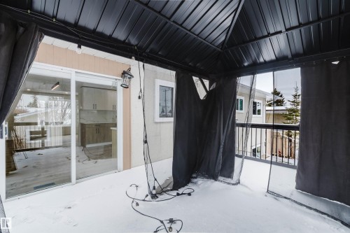 This property features an enclosed outdoor space with a dark metal roof structure and sheer dark curtains - 11528 42 Avenue, Edmonton, AB - Outdoor With Exterior