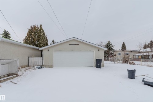 Detached garage with a white garage door, featuring an exterior light fixture - 11528 42 Avenue, Edmonton, AB - Outdoor With Exterior