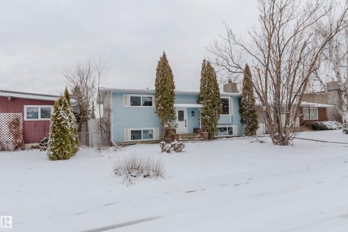 Property exterior featuring a light blue siding, white trim, and a prominent front entrance with a white door - 11528 42 Avenue, Edmonton, AB - Outdoor With Facade