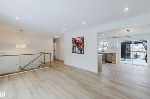 Spacious living area featuring light-toned flooring, recessed lighting, and a modern chandelier - 11528 42 Avenue, Edmonton, AB - Indoor