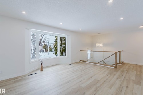 This bright, open room features light-toned flooring, a bay window with white trim, and recessed lighting - 11528 42 Avenue, Edmonton, AB - Indoor Photo Showing Other Room