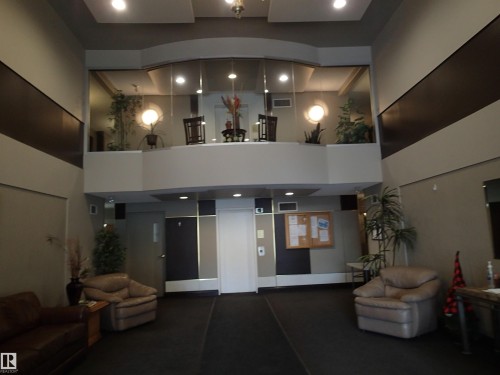 Spacious lobby area featuring high ceilings, recessed lighting, and a mezzanine level with decorative accents - 206 10208 120 Street, Edmonton, AB - Indoor Photo Showing Other Room