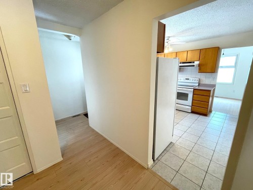 The property features a kitchen with wood cabinetry, a white stove, and tiled floors - 44 Arlington Drive, St. Albert, AB - Indoor Photo Showing Kitchen