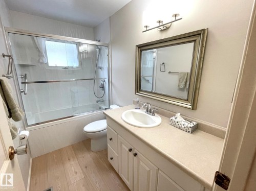 The bathroom features a vanity with a light-colored countertop and a framed mirror above - 44 Arlington Drive, St. Albert, AB - Indoor Photo Showing Bathroom