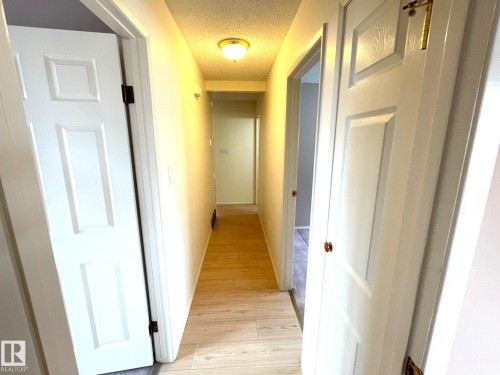 The hallway features light-toned flooring and white panel doors - 44 Arlington Drive, St. Albert, AB - Indoor Photo Showing Other Room