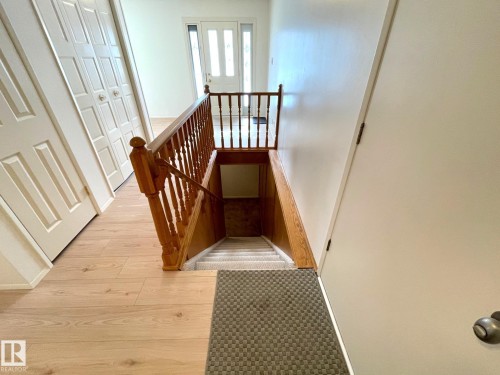 The property features a staircase with a wooden handrail and banister, leading to a lower level - 44 Arlington Drive, St. Albert, AB - Indoor Photo Showing Other Room