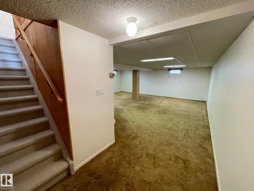 The lower level features an expansive carpeted area with overhead lighting and a window - 44 Arlington Drive, St. Albert, AB - Indoor Photo Showing Other Room