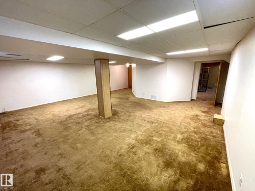 Spacious room with white walls, carpeted flooring, and ceiling tile with integrated lighting - 44 Arlington Drive, St. Albert, AB - Indoor Photo Showing Basement