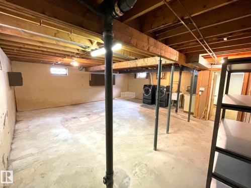 Spacious basement with concrete flooring, exposed ceiling joists, and a utility sink - 44 Arlington Drive, St. Albert, AB - Indoor Photo Showing Basement