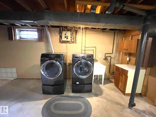 Laundry area featuring a utility sink, cabinetry, and exposed ceiling beams - 44 Arlington Drive, St. Albert, AB - Indoor Photo Showing Laundry Room