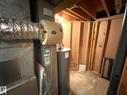 The property features a water heater and a furnace unit with attached ductwork and a humidifier - 44 Arlington Drive, St. Albert, AB - Indoor Photo Showing Basement