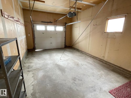Attached garage featuring a window, an overhead door, and a garage door opener - 44 Arlington Drive, St. Albert, AB - Indoor Photo Showing Garage