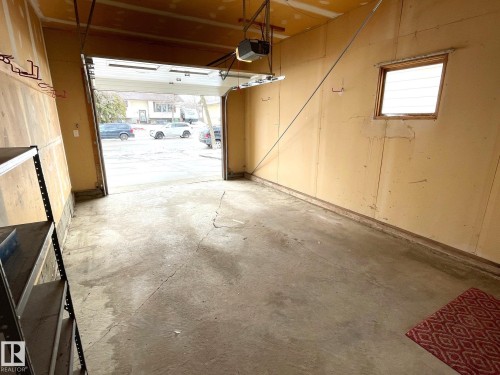 The property includes a single-car garage with a concrete floor, a window, and an operational garage door opener - 44 Arlington Drive, St. Albert, AB - Indoor