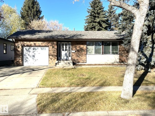 The property features a brick facade, an attached garage with a white door, and a front entrance with a white door and side lights - 44 Arlington Drive, St. Albert, AB - Outdoor
