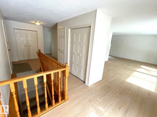The property features light-toned flooring, a wooden staircase, and white walls throughout - 44 Arlington Drive, St. Albert, AB - Indoor Photo Showing Other Room