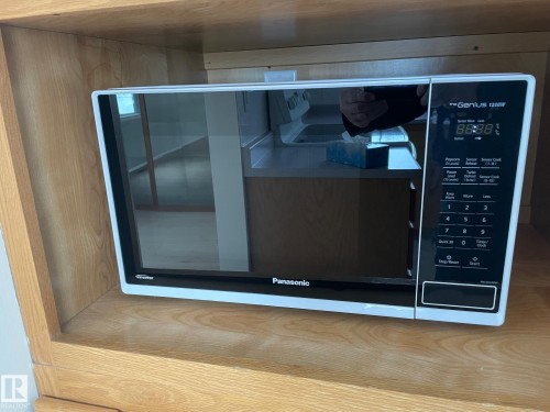 Built-in microwave oven, seamlessly integrated into custom wooden cabinetry - 44 Arlington Drive, St. Albert, AB - Indoor Photo Showing Other Room