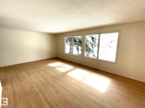 This living space features light-toned flooring and a bank of windows providing ample natural light - 44 Arlington Drive, St. Albert, AB - Indoor Photo Showing Other Room