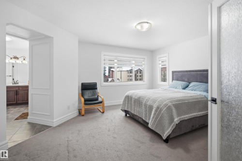 This property features a spacious room with light gray carpeting and white walls - 469 Ainslie Crescent Sw, Edmonton, AB - Indoor Photo Showing Bedroom
